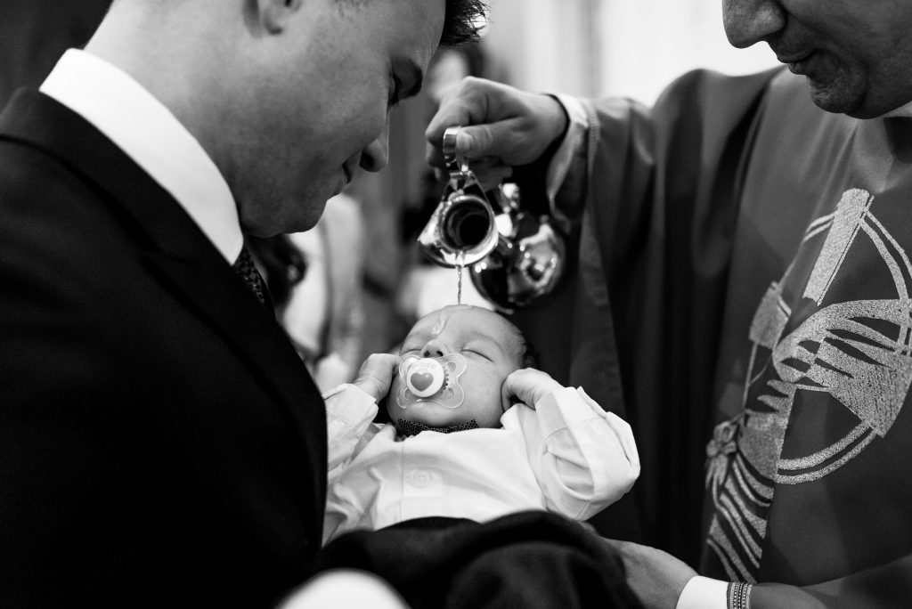 baptism black and white photo priest pouring water on babys forehead
mamagare paketi krštenje