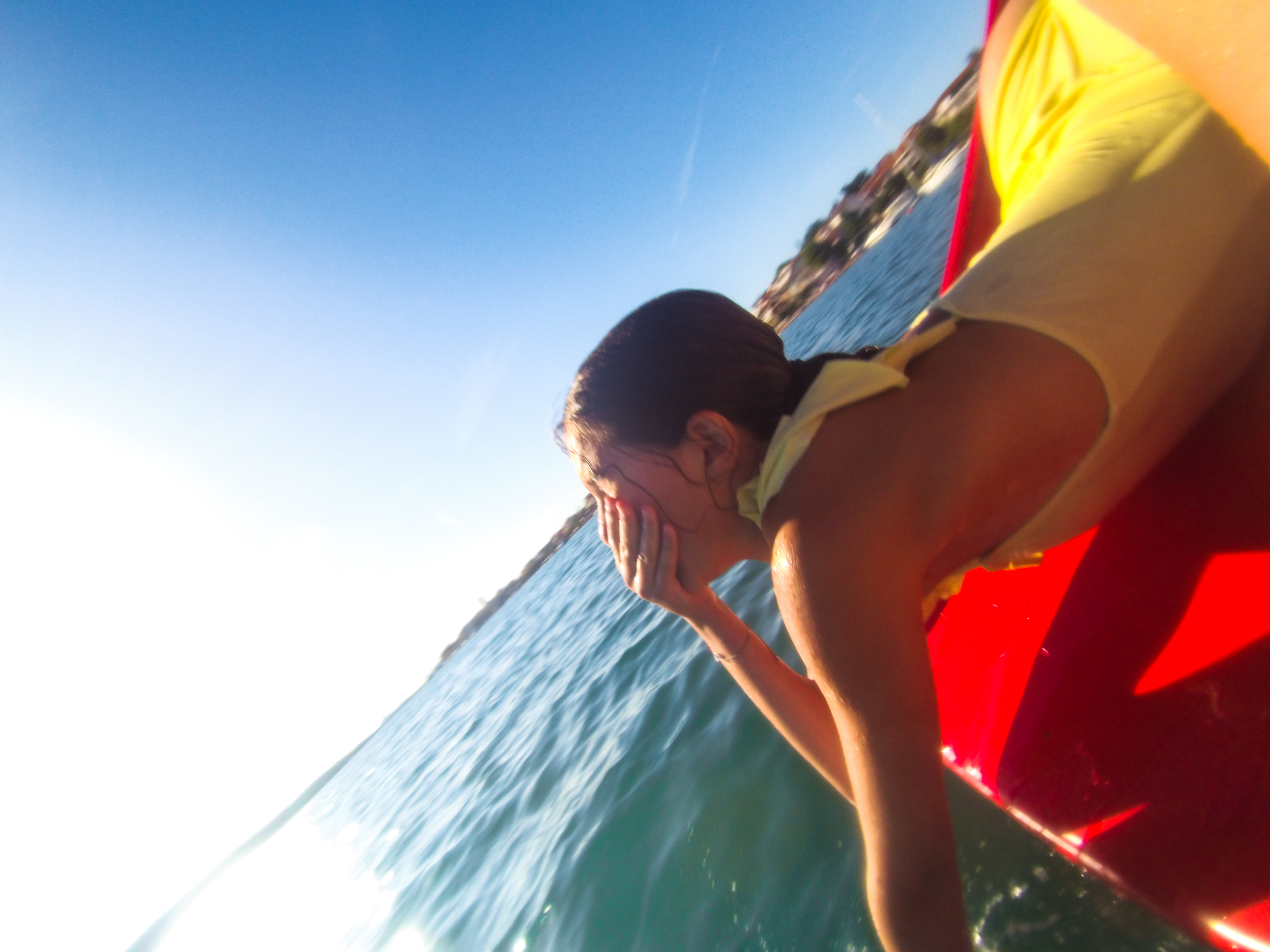 a girl in yellow swimsuit sliding down the paddle boat toboggan jumping on the head into water Croatia