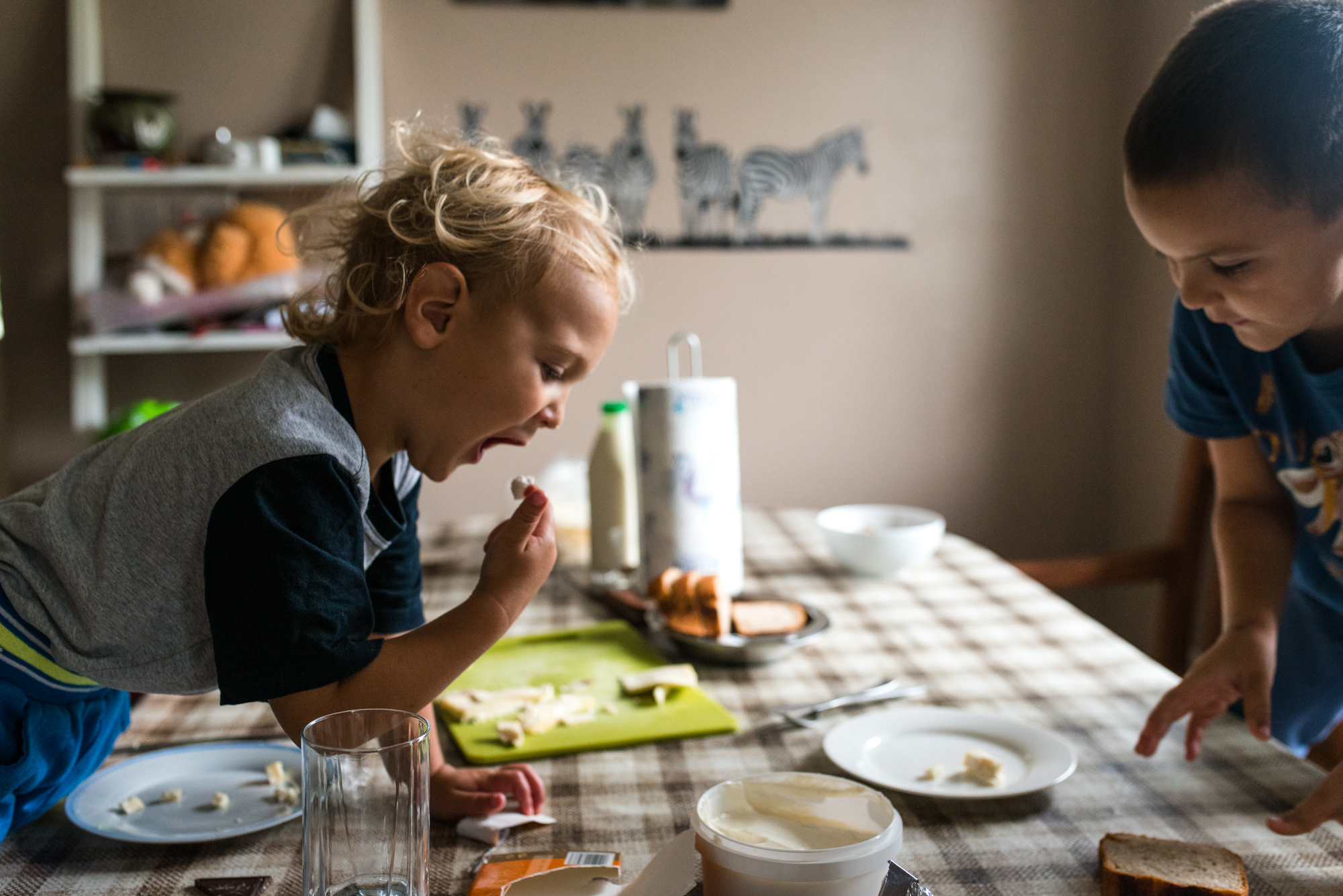 Obiteljska-dokufotografija-Zagreb-boy licking his fingers during breakfast