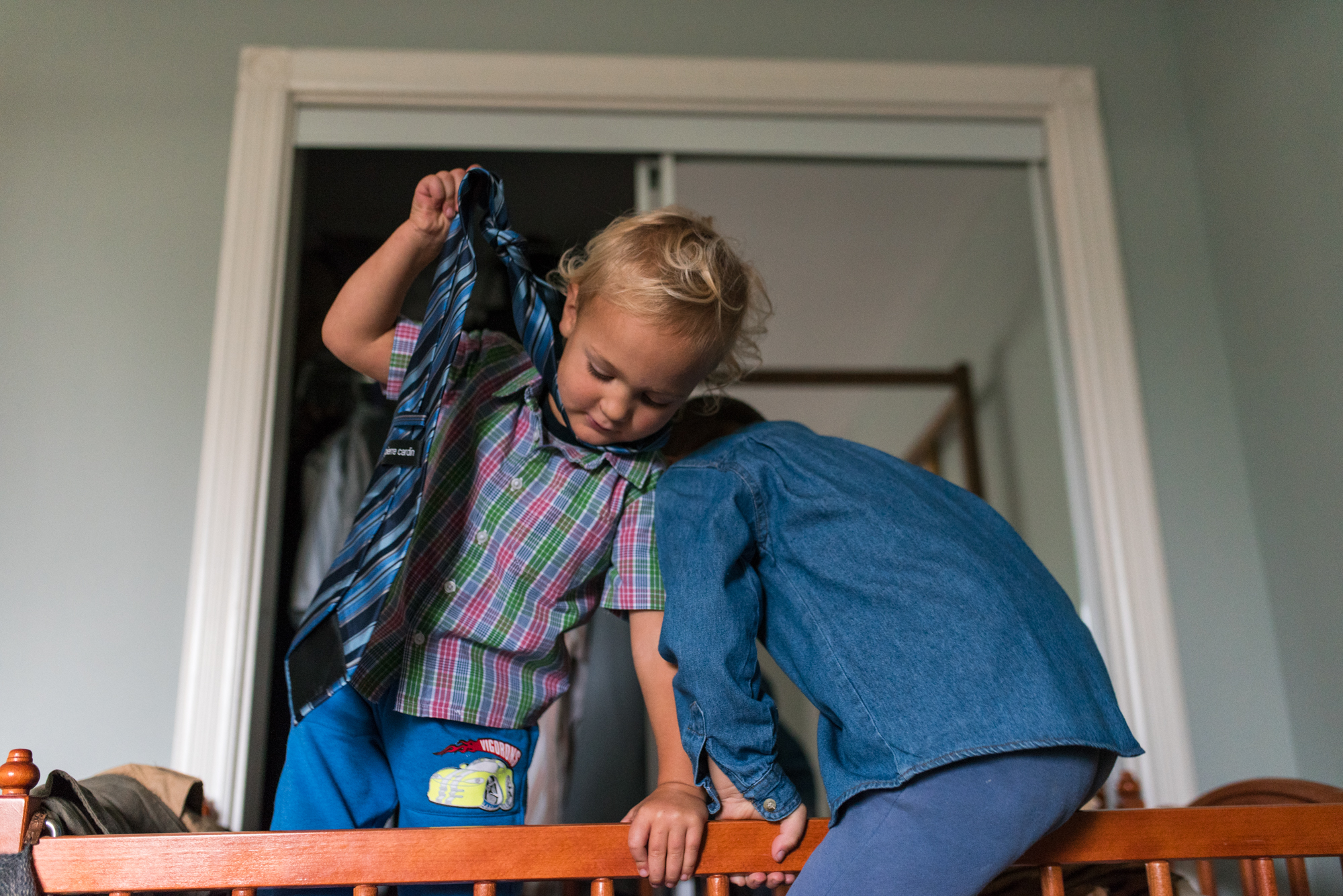 Obiteljska-dokufotografija-Zagreb-boy wearing fathers tie choking